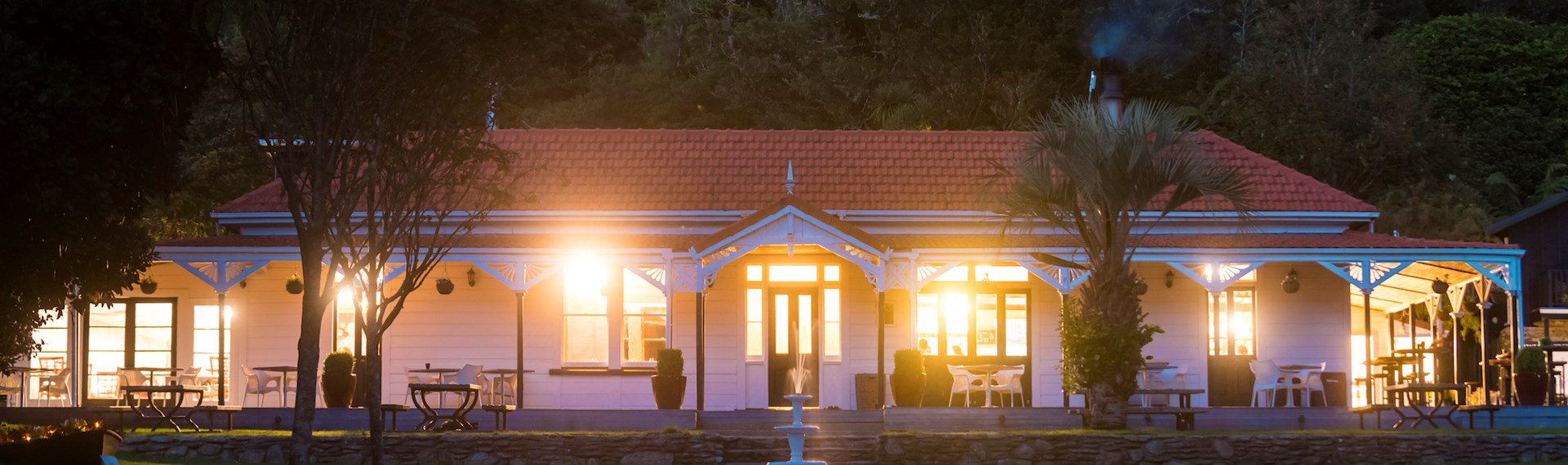 The front of historic Howden House at Furneaux Lodge showing the long verandah and orange tiled roof, in the Marlborough Sounds at the top of New Zealand's South Island.
